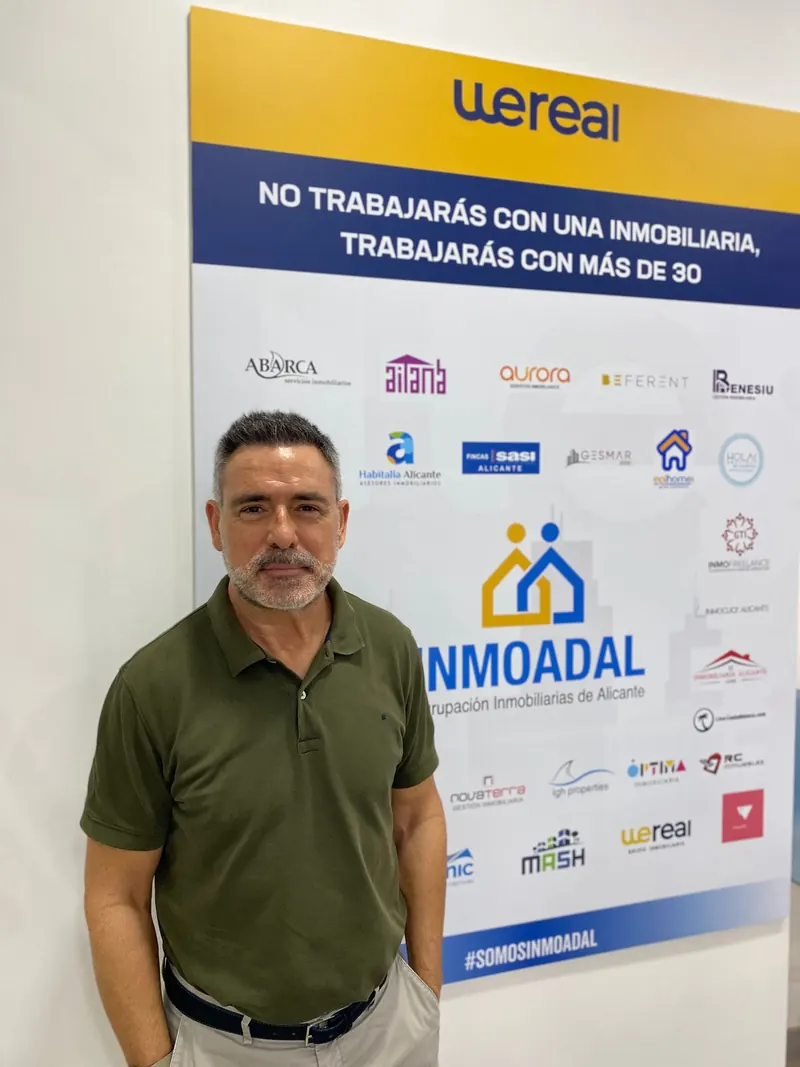 Javier Pastor Cobos junto al panel de INMOADAL, Agrupación Inmobiliarias de Alicante